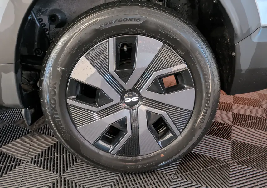 Gros plan sur la roue avant droite du Dacia Jogger gris schiste métal, mettant en valeur la jante au design moderne bicolore.