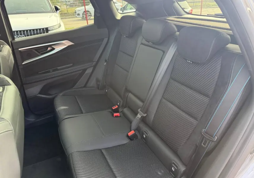 Vue latérale droite des sièges arrière en tissu carbone et Alcantara noir avec surpiqûres bleues du Renault Austral 2026.