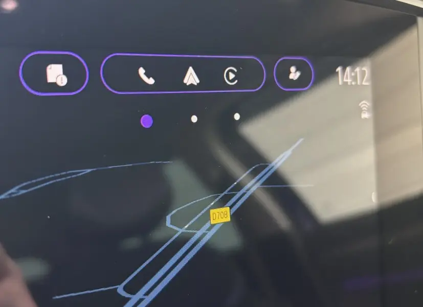 Écran tactile central affichant la navigation dans une Renault Mégane bleu, vue rapprochée intérieure.