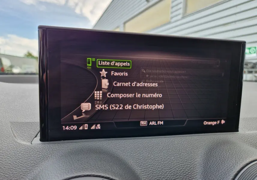 Écran central de l'Audi Q2 35 TFSI 2023 affichant la liste d'appels avec interface connectée, vue intérieure frontale.