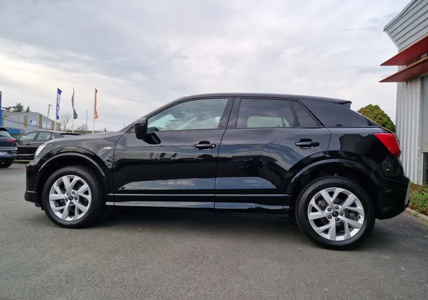 Audi Q2 35 TFSI noir mito metal vue de profil côté gauche, avec jantes alliage et lignes épurées.