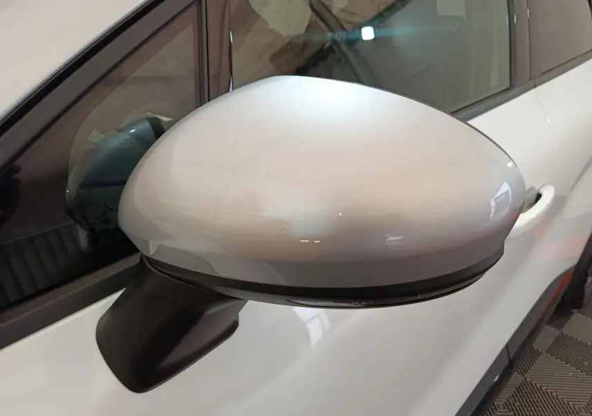 Rétroviseur côté gauche blanc du Renault Captur 2025 techno E-Tech full hybrid, avec clignotant intégré visible.