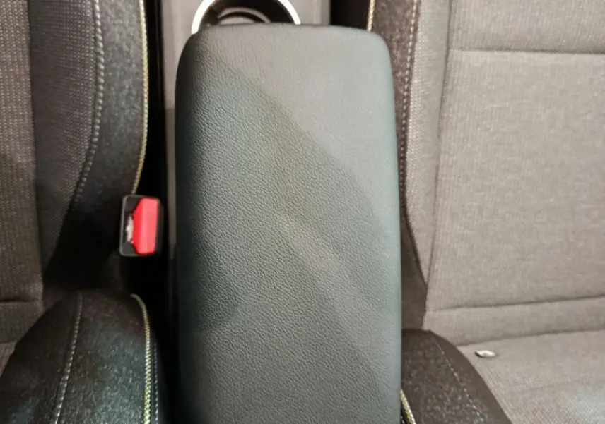 Accoudoir central noir entre les sièges avant en tissu gris du Renault Captur Techno E-Tech hybride 2025.