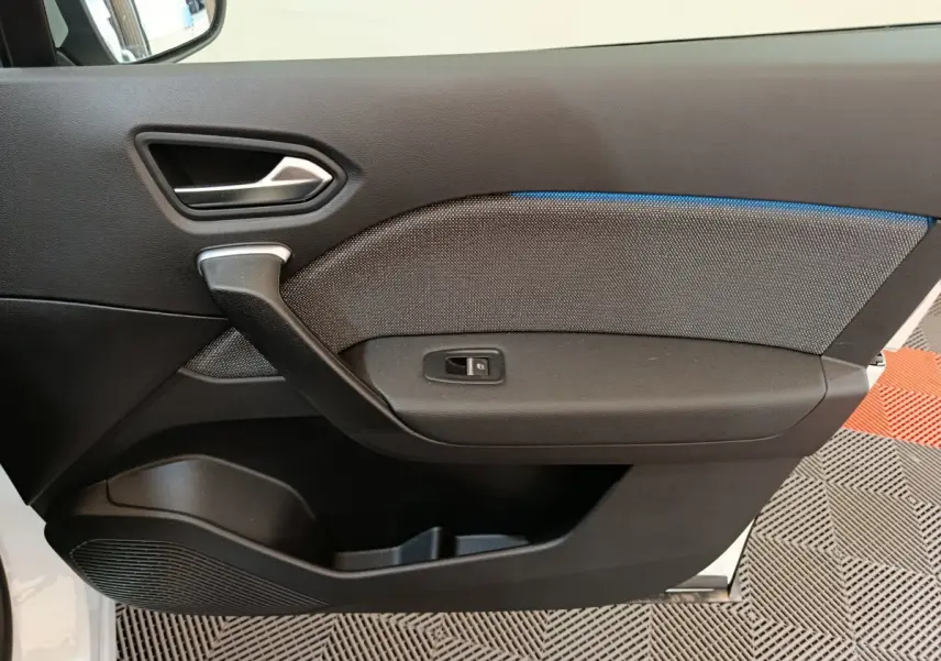 Panneau de porte intérieur côté gauche noir et gris avec éclairage d'ambiance bleu sur Renault Captur blanc 2025.