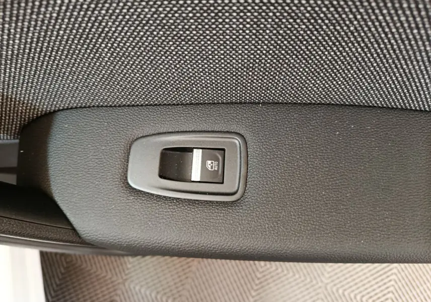 Bouton de commande de lève-vitre automatique sur la porte intérieure noire d'un Renault Captur blanc 2025.