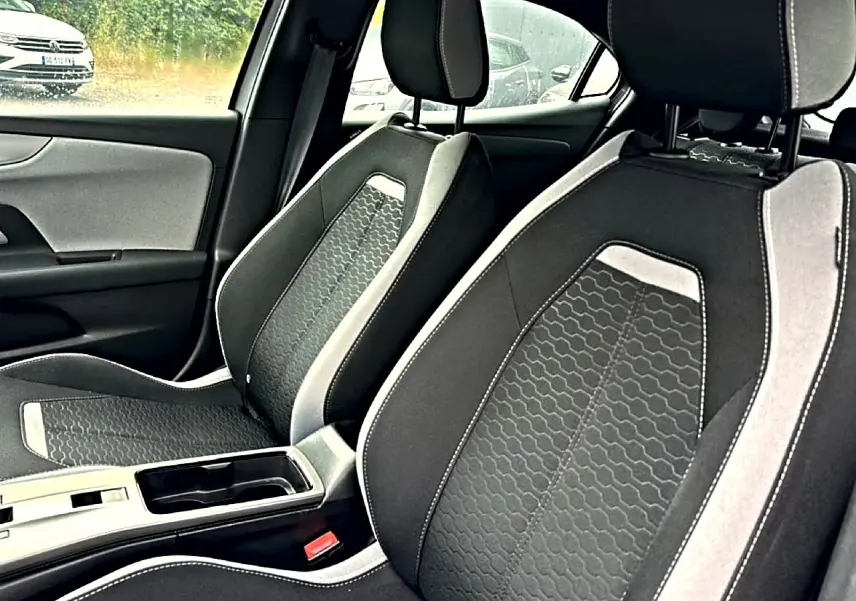 Vue intérieure rapprochée des sièges avant gris foncé et clair de l’Opel Mokka 2025 avec console centrale visible.