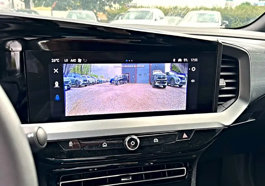 Vue rapprochée de l’écran tactile intérieur affichant la caméra de recul du tableau de bord noir et gris du Opel Mokka gris.