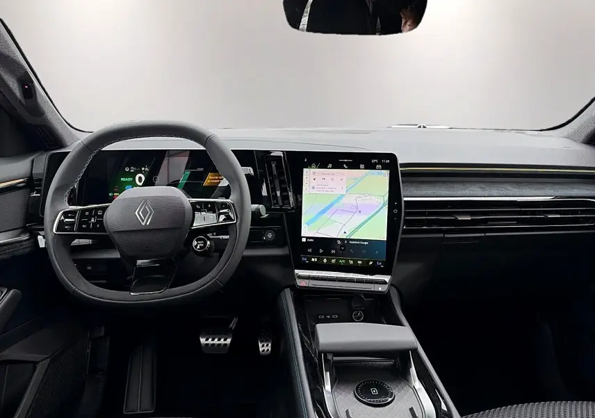 Vue intérieure avant du Renault Austral gris schiste, volant multifonction et grand écran tactile central avec navigation.
