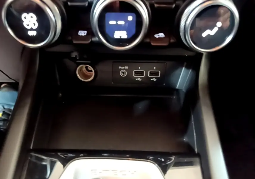 Vue rapprochée de la console centrale du Renault Arkana Business E-TECH 145, avec commandes de climatisation et ports USB visibles.