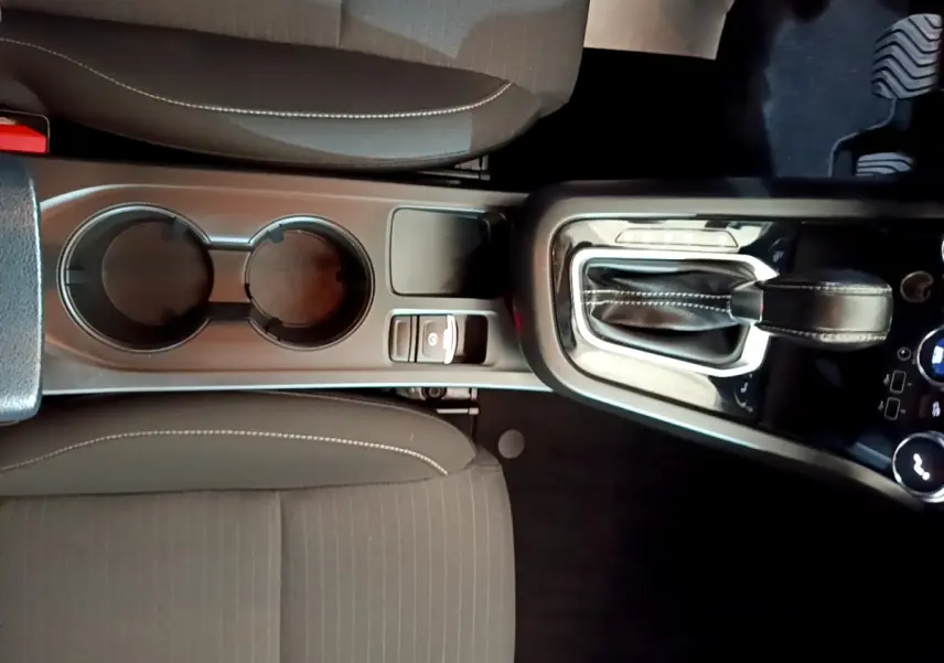 Vue plongeante sur la console centrale du Renault Arkana Business E-TECH 145, avec levier de vitesse et porte-gobelets.