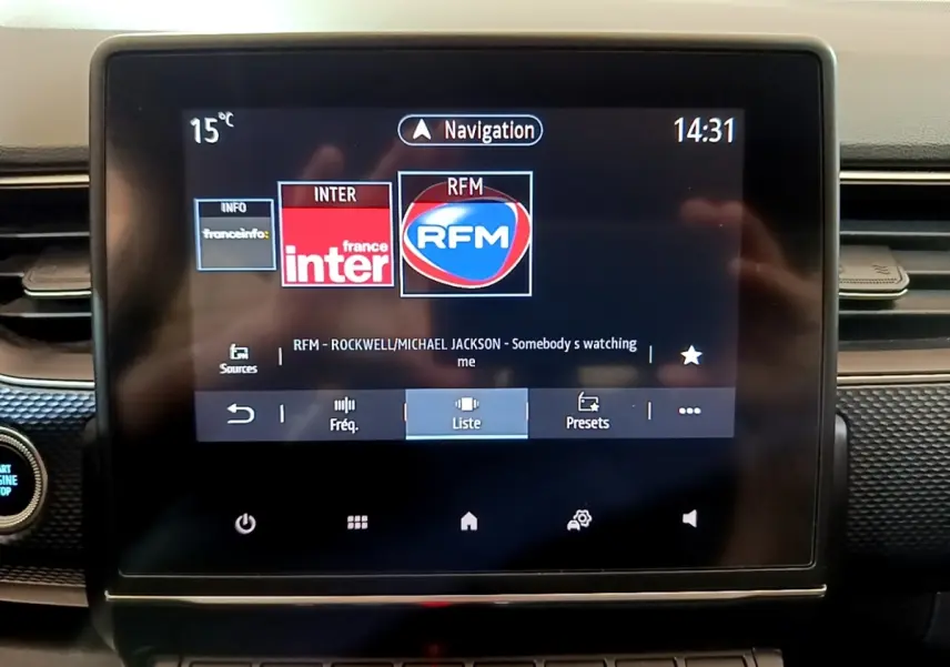 Écran tactile central du tableau de bord du Renault Arkana Business E-TECH 145 affichant la radio et la navigation.