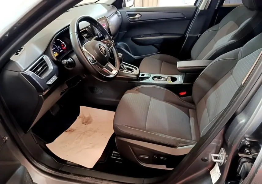 Intérieur avant droit du Renault Arkana Business E-TECH 145 gris foncé, avec volant multifonctions et console centrale moderne.