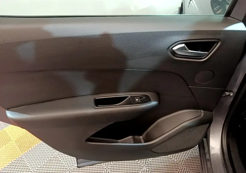 Gros plan sur la porte intérieure côté droit du Renault Arkana Business E-TECH 145 gris foncé, avec poignée et commande de vitre.