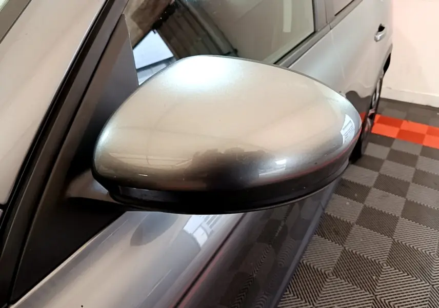 Rétroviseur côté conducteur gris foncé du Renault Arkana Business E-TECH 145 vu en gros plan depuis l'avant gauche.