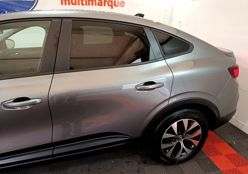 Profil côté droit du Renault Arkana Business E-TECH 145 gris foncé, mettant en valeur ses lignes fluides et la jante alliage distinctive.
