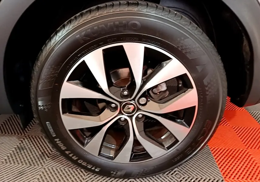 Gros plan sur la jante alliage bicolore et pneu Kumho du Renault Arkana Business E-TECH gris foncé.