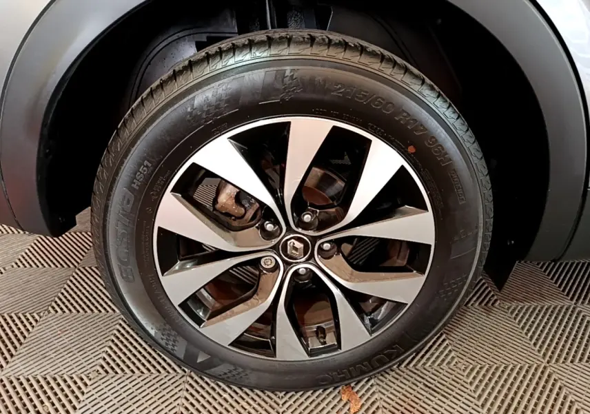 Gros plan sur la roue avant droite du Renault Arkana Business E-TECH 145 gris foncé avec jante alliage bicolore.