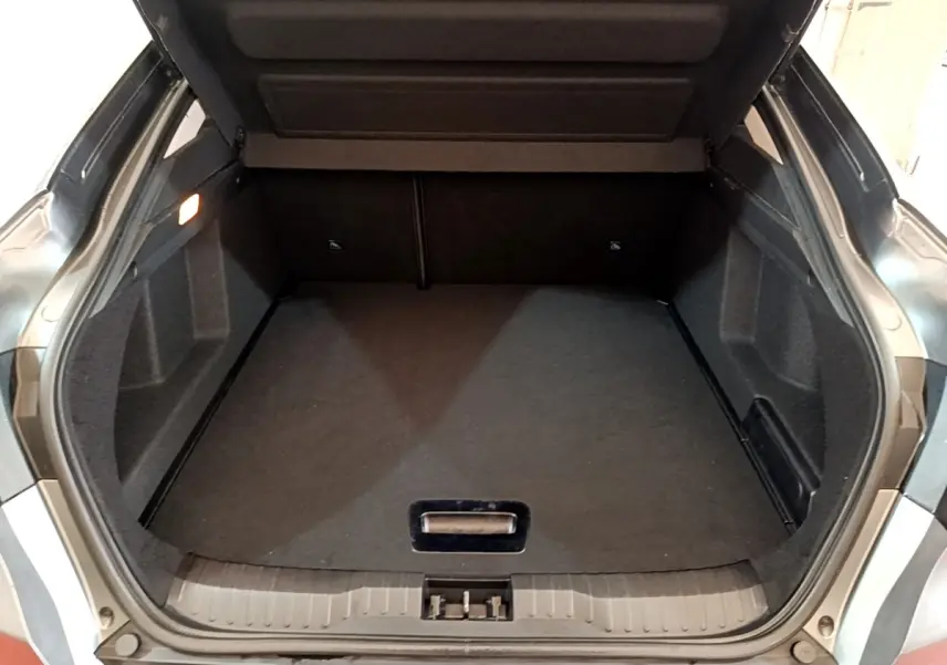 Coffre ouvert gris foncé du Renault Arkana Business E-TECH 145, vue arrière montrant l'espace de chargement vide.