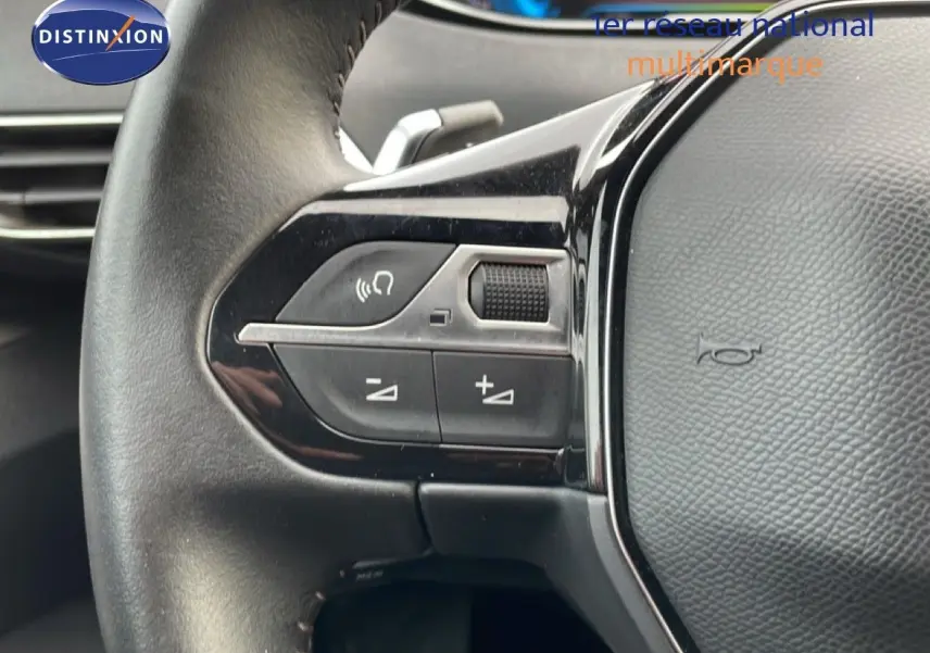 Gros plan sur la partie gauche du volant noir du Peugeot 3008 bleu Célèbes Métal, avec commandes intégrées.