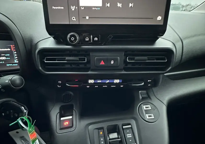 Vue intérieure du tableau de bord du Citroën Berlingo 2025, avec écran tactile central et commandes de climatisation.