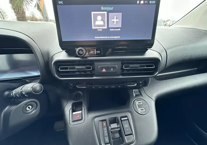 Vue rapprochée du tableau de bord du Citroën Berlingo 2025 gris Artense, avec écran tactile et commandes de boîte automatique.