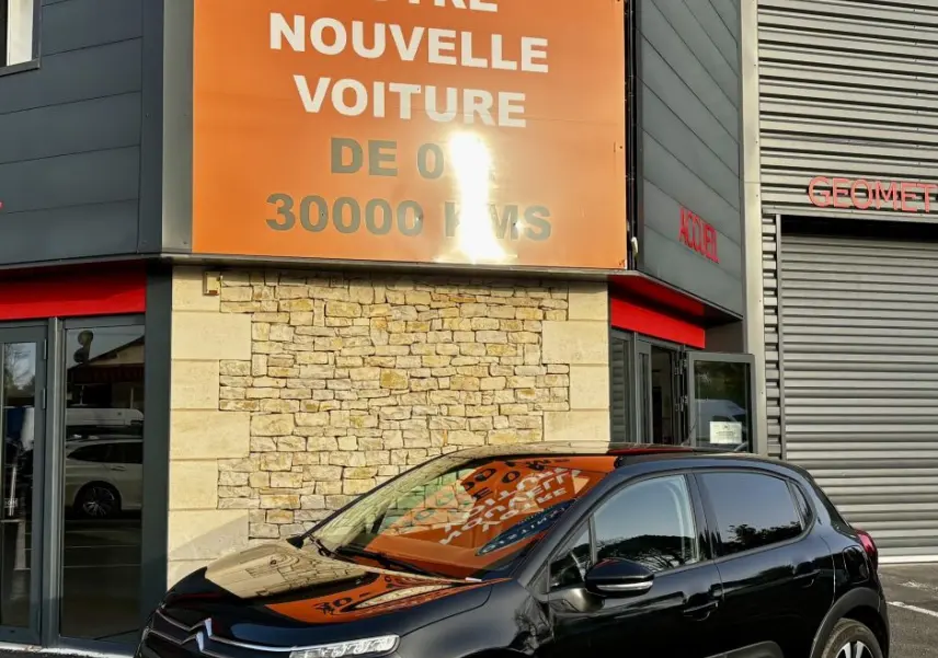 Citroën C3 noire vue en 3/4 avant droit, avec ses phares LED et protections latérales blanches distinctives.