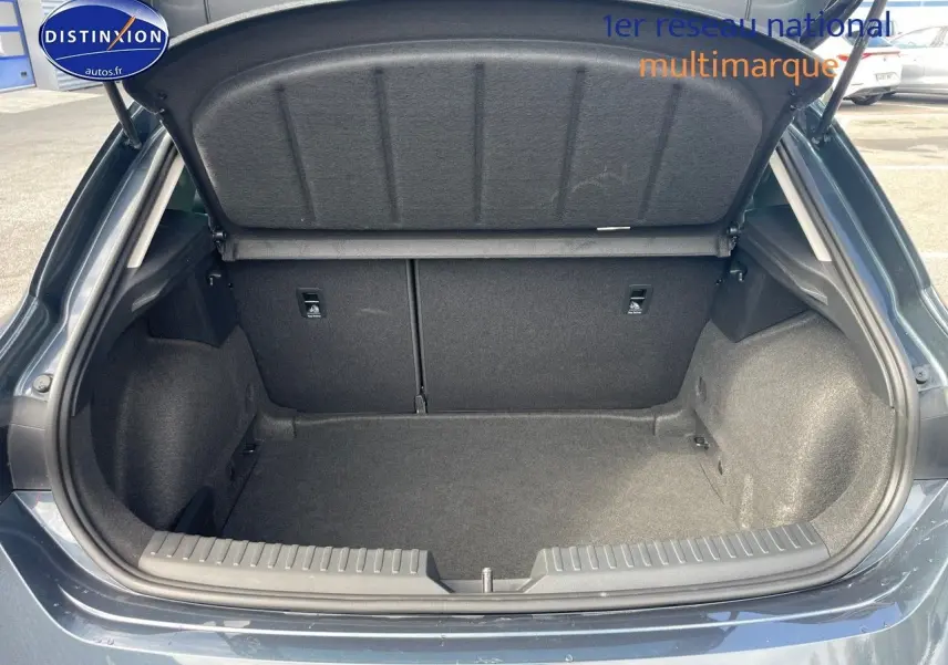 Coffre ouvert vu de l'arrière d'une SEAT LEON IV gris magnétique métal, montrant un espace de chargement propre et spacieux.