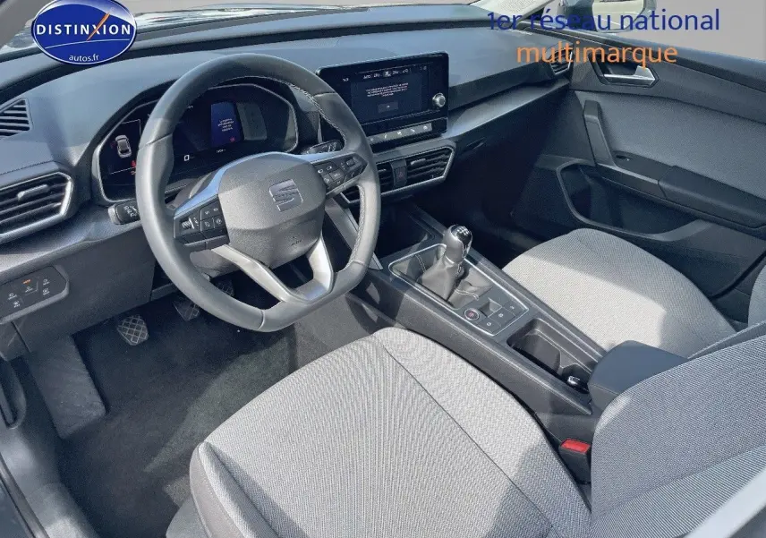 Intérieur avant de la SEAT LEON IV 1.5 TSI gris avec tableau de bord moderne et boîte manuelle visible entre les sièges.