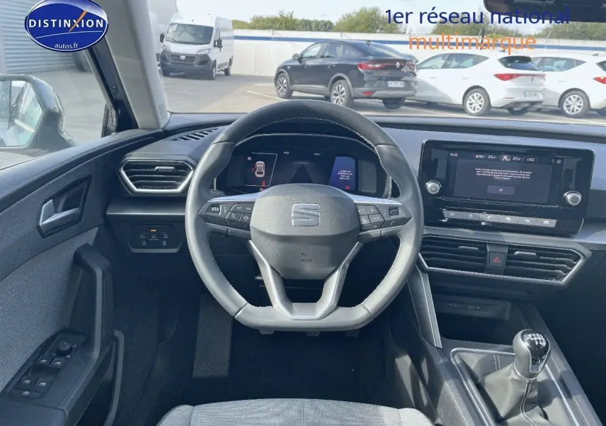 Vue intérieure du tableau de bord et volant de la SEAT LEON IV gris magnétique avec boîte manuelle et écran tactile central.