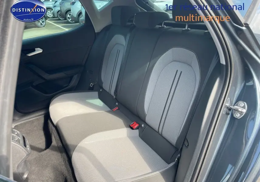 Vue intérieure sur les sièges arrière gris clair et foncé du SEAT LEON IV 2024, porte arrière droite ouverte.