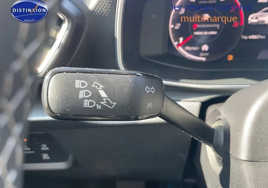 Le commodo de clignotant et feux sur le côté gauche du tableau de bord d'une SEAT Leon gris magnétique 2024.