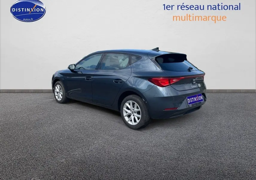 Vue 3/4 arrière droite d'une SEAT Leon gris magnétique métal 2024 avec feux LED et jantes argentées.