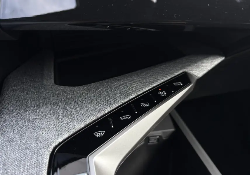 Détail du panneau de commandes climatisation avec finition tissu gris dans l'habitacle du Peugeot 5008 blanc.
