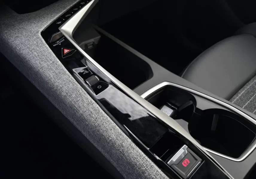 Gros plan sur la console centrale tissu gris et la commande de frein électrique du Peugeot 5008 Hybrid blanc Okénite.