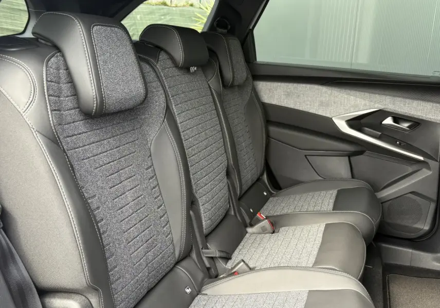 Vue latérale droite des sièges arrière en tissu gris et cuir noir du Peugeot 5008 Hybrid 145 e-DSC6 Allure 2025.