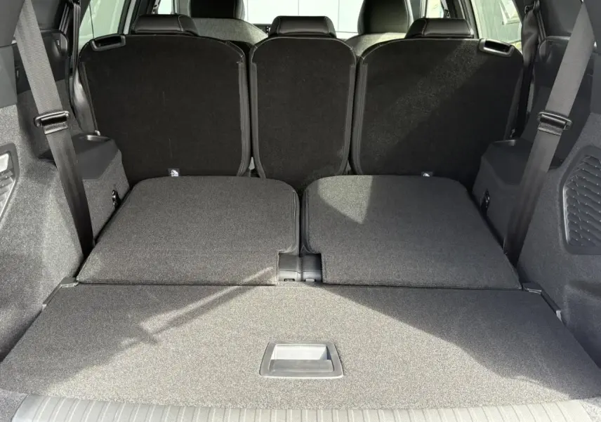 Coffre du Peugeot 5008 Hybrid blanc vu de l'arrière avec banquette arrière rabattue pour un grand espace de chargement.
