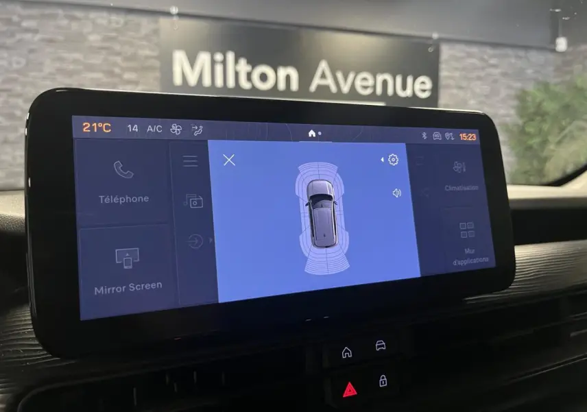 Écran tactile central du Jeep Avenger 2024 affichant l'aide au stationnement avec vue du véhicule gris.