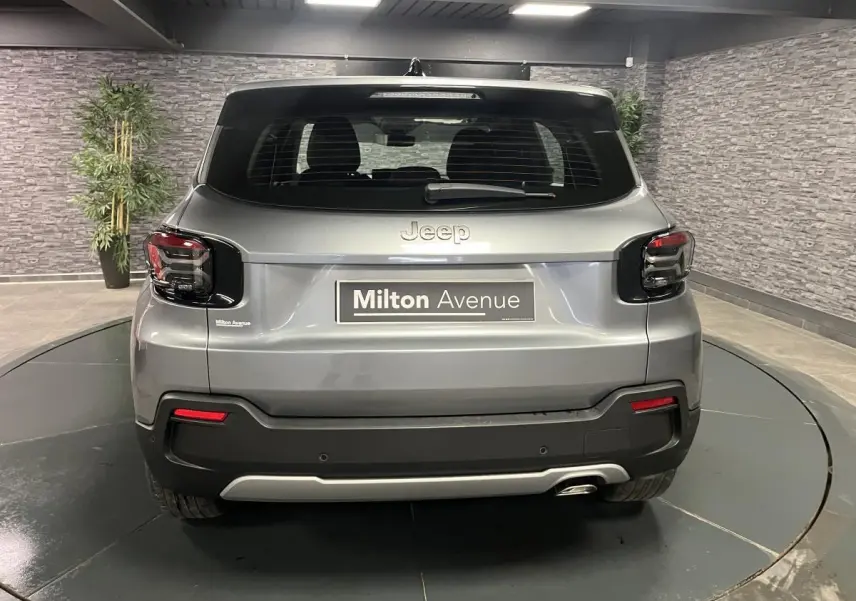 Vue arrière d'un Jeep Avenger gris métallisé 2024 avec feux arrière sombres et plaque Milton Avenue.