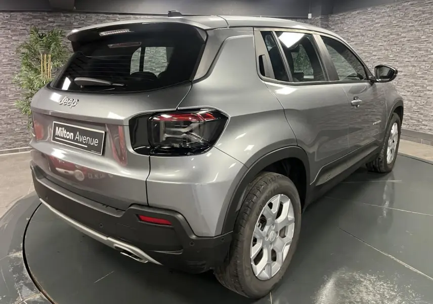 Vue 3/4 arrière droite du Jeep Avenger gris métallisé avec feux arrière sombres et jantes alliage 17 pouces.