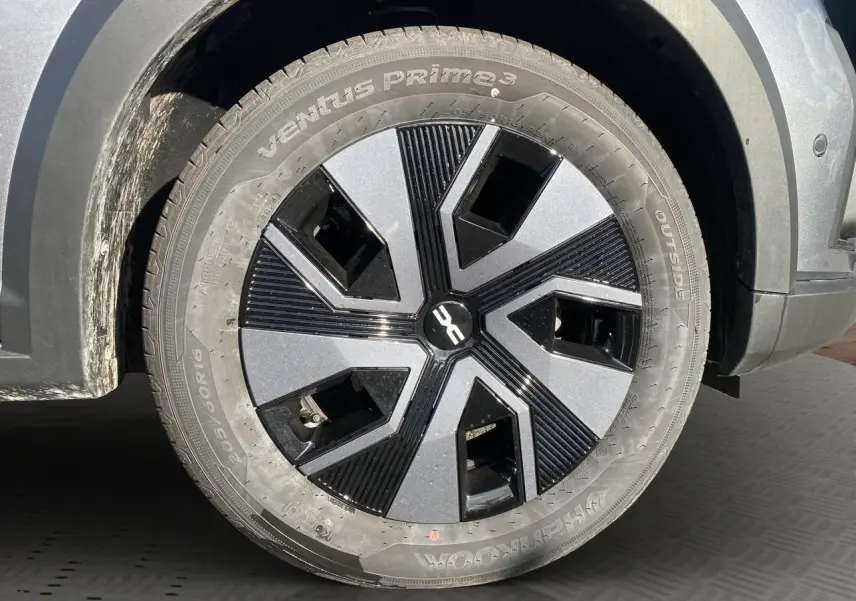 Gros plan sur la roue avant droite de la Dacia Sandero Stepway gris schiste avec jante noire et grise design moderne.