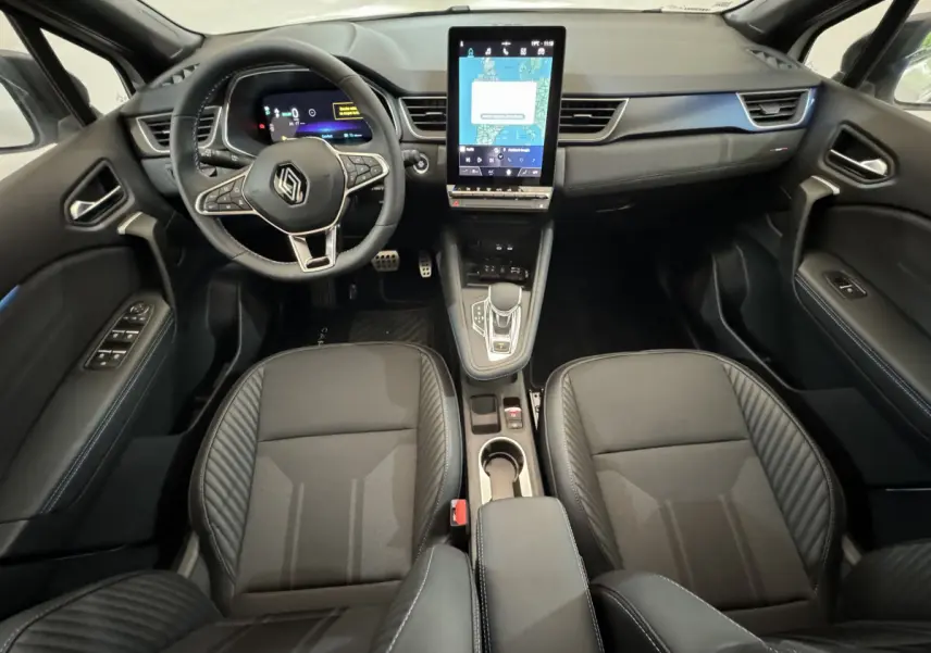 Intérieur noir du Renault Captur esprit Alpine E-Tech 2025, vue frontale sur tableau de bord et sièges avant.