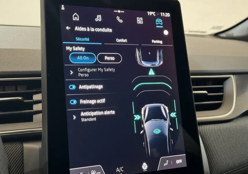 Écran tactile central du Renault Captur blanc 2025 montrant les aides à la conduite et réglages de sécurité.