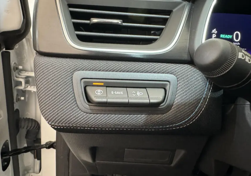 Détail du tableau de bord côté gauche du Renault Captur blanc 2025 esprit Alpine E-Tech avec boutons E-SAVE et réglage phares.