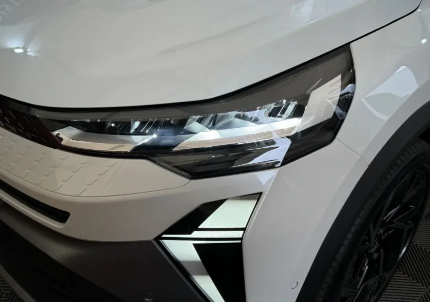 Gros plan sur le phare avant droit blanc du Renault Captur esprit Alpine E-Tech 2025 avec signature lumineuse LED distinctive.