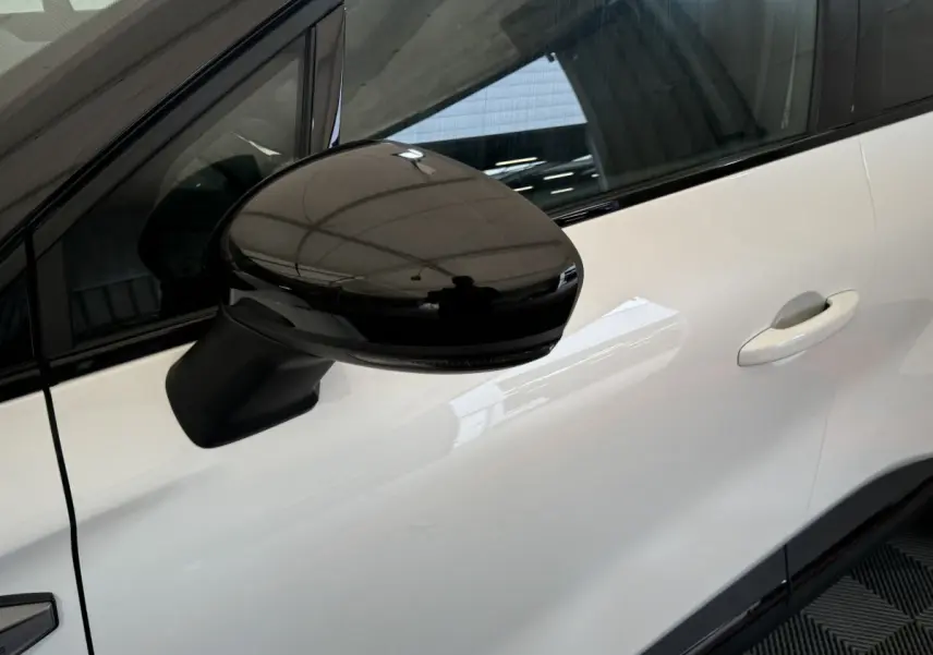 Gros plan sur le rétroviseur noir côté gauche d'un Renault Captur blanc esprit Alpine E-Tech 2025.