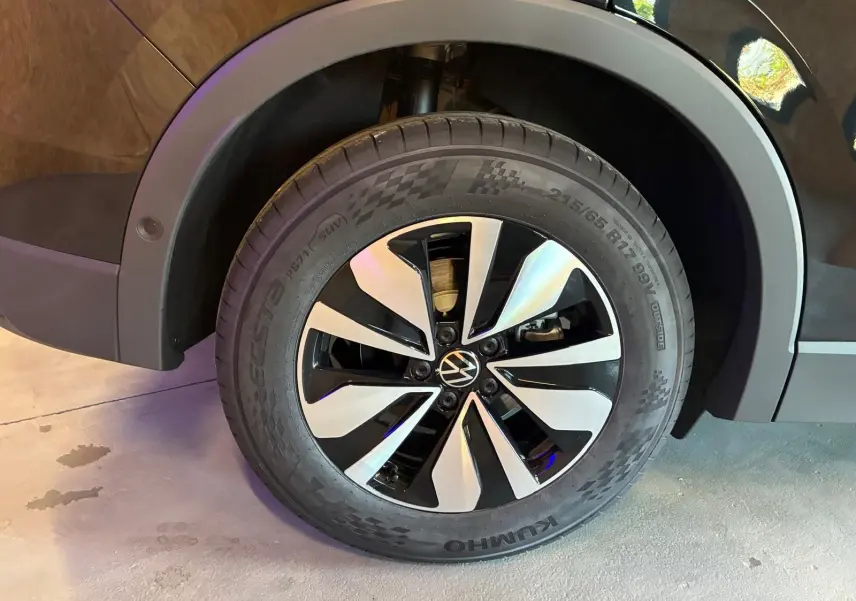 Gros plan sur la roue avant droite du Volkswagen Tiguan noir Grenadilla, mettant en valeur la jante bi-ton moderne.