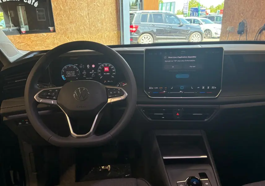 Vue intérieure du tableau de bord du Volkswagen Tiguan 2026, volant multifonction et écran tactile central allumé.