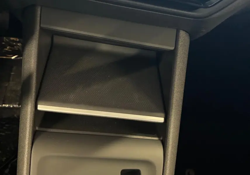 Vue rapprochée de la console centrale noire du Volkswagen Tiguan 2026, avec bouton start/stop et commande électronique frein à main.