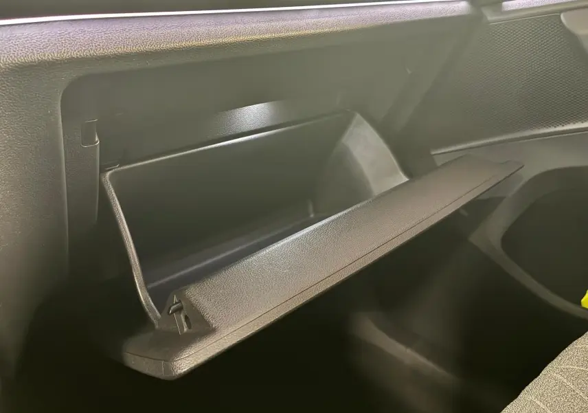 Vue intérieure du Volkswagen Tiguan 2026 noir Grenadilla, boîte à gants ouverte côté passager.