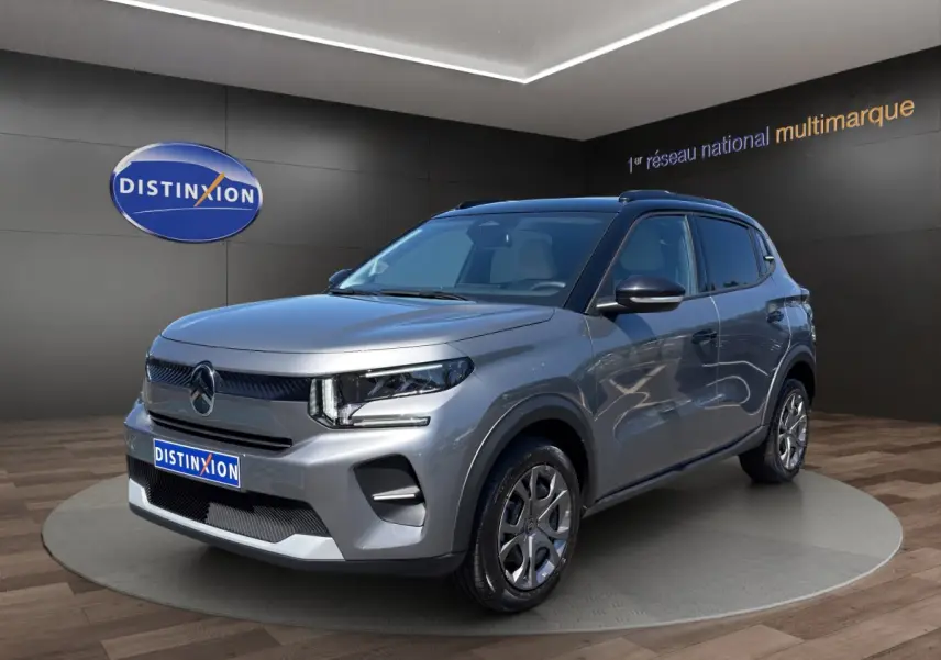 Citroën C3 hybride gris foncé vue 3/4 avant droite avec jantes alliage et toit noir en showroom.